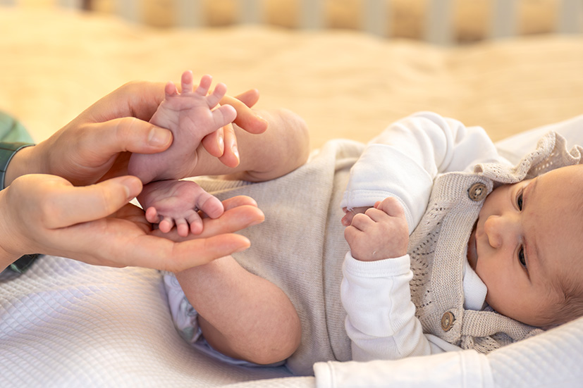 Hände, die Babyfüße halten