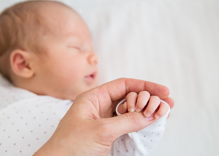 Bild eines Babys, Fokus auf Babyhand die gehalten wird